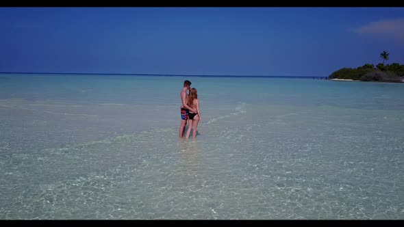 Two lovers suntan on beautiful seashore beach time by aqua blue ocean with white sand background of 