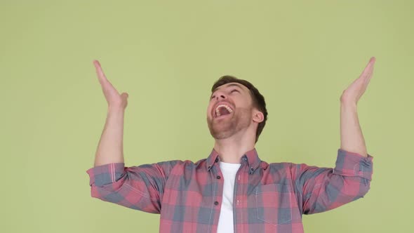 Handsome Guy in a Shirt Looking Up and Shouting with Happiness Yes