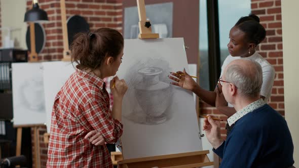 Elder Student Talking to People in Art Class About Drawing Technique