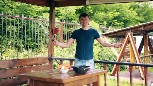 Guy is Cooking Pilaf Is in the Summer House Preparing for a Picnic He Points at the Table and Smiles