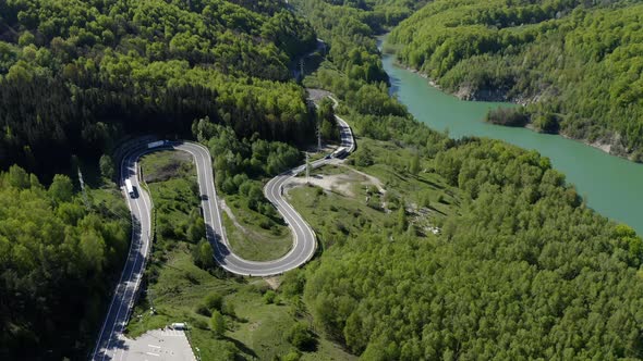 Aerial View Of Curved Asphalt Road In Lush Green Mountain By The Teleajen River In Maneciu, Romania.