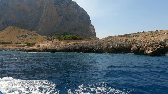 Typical old Sicilian seafront Tonnara Del Secco used for tuna fishing as seen from boat in Sicily. I