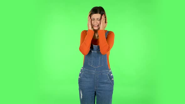 Girl Carefully Examines Something Then Fearfully Covers Her Face with Her Hand. Green Screen