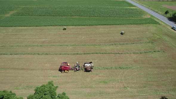 Aerial View of an Amish Farmer Harvesting His Crop with 4 Horses and Modern Equipment