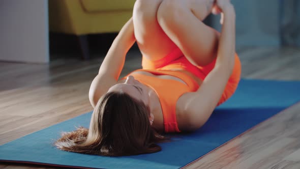 Young Pretty Woman Stretching Her Legs on Yoga Mat