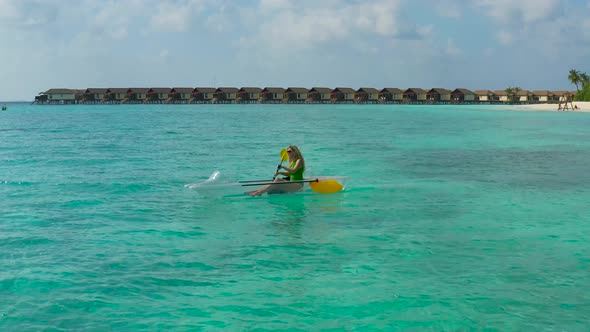 Young Woman Floating Transparent Kayak on Water Villas Background on Tropical Island in Maldives