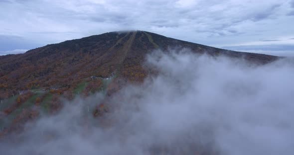 Flight Through the Clouds Towards a Mountain
