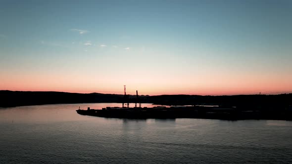 Cranes from Larvik cargo harbor with a beautiful blue and orange sunset in the background