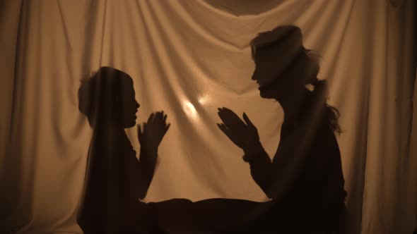 Silhouettes of Woman and Boy Telling Stories Using Shadow Play Clapping Their Hands