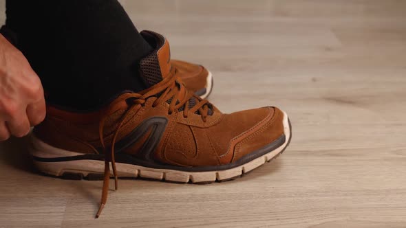 Side View of a Man's Foot in a Black Sock Wearing a Brown Leather Walking Sneaker