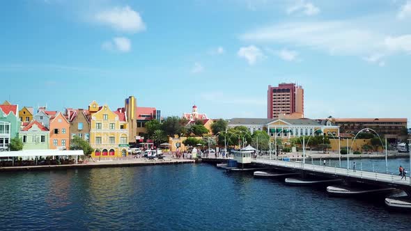 Pan left of the Queen Emma Bridge in St. Anne's Bay and the skyline of the Punta district in Willems