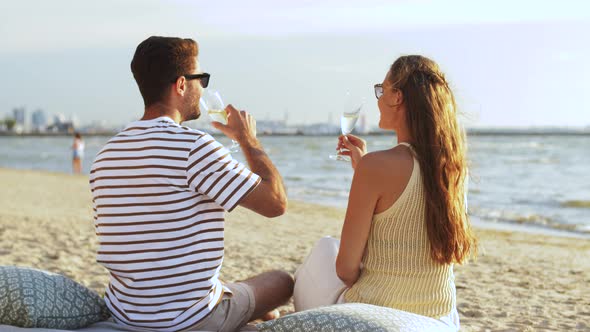 Happy Couple Drinking Champagne on Summer Beach