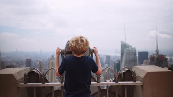 Boy Looking Through Telescope To View New York Skyscrapers