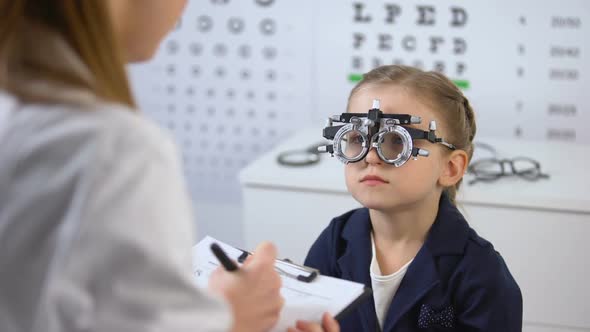 Cute Girl in Optical Trial Frame Waiting Prescription From Ophthalmologist