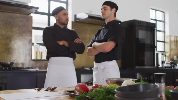 Caucasian and mixed race chefs looking at camera and smiling