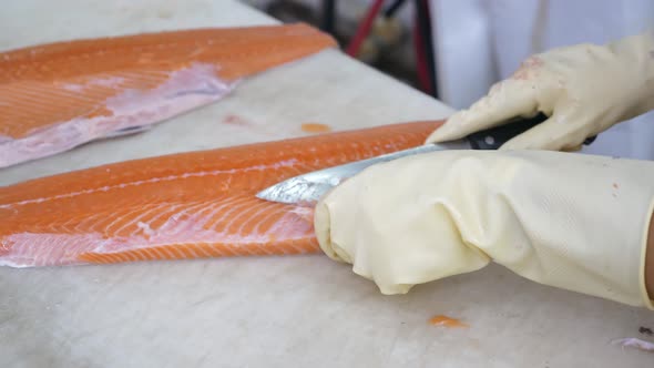 Closeup of Worker Hands Cutting and Cleaning Salmon Fillet Big Chopping Knife