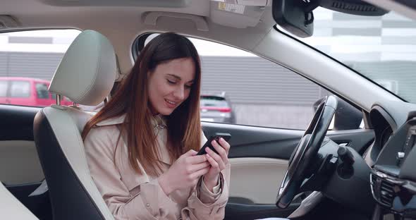 Portrait Young Woman Using Her Smartphone in Car