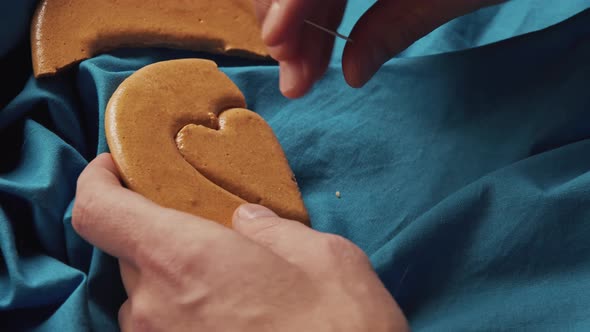 Men's Hands Break Sugar Cookies Candy in the Shape of a Heart