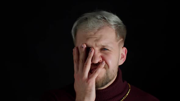 Disappointed Man Doing Face Palm Gesture on Black Background