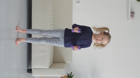 Little Girl Working Out with Dumbbells Indoors