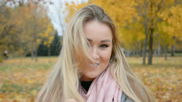 Beautiful Blonde Russian Girl Looking at the Camera and Smiling in the Autumn City