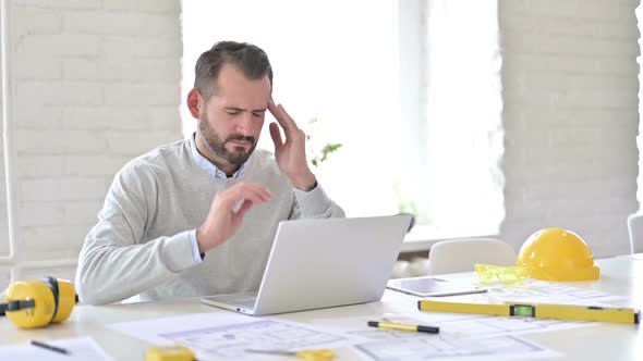 Young Architect with Laptop Having Headache in Office