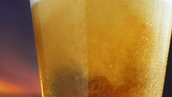 Slow-motion Macro Cold Beer Is Poured Into a Glass with Perspiration. Beer Bubbles Rise To the