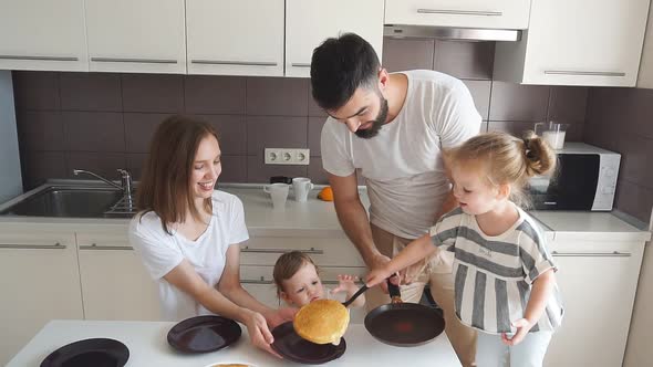 Cheerful Smiling Couple and Their Kids Coking Tasty Cake