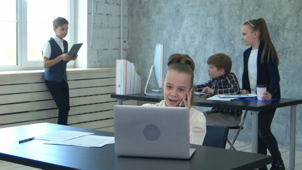 Seven years old business girl working in office interior