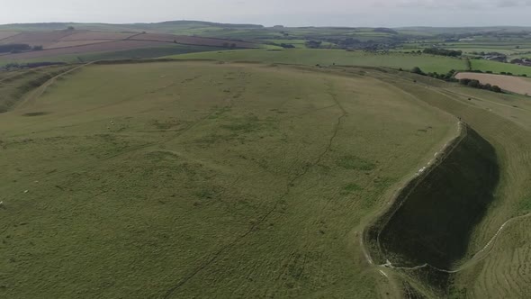 Rotating aerial around the famous  Iron-age hill fort of Maiden Castle, Near Dorchester, Dorset. Cro