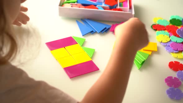 a Girl at a Round White Table Plays Educational Games a House Made of Designer Children's Hands