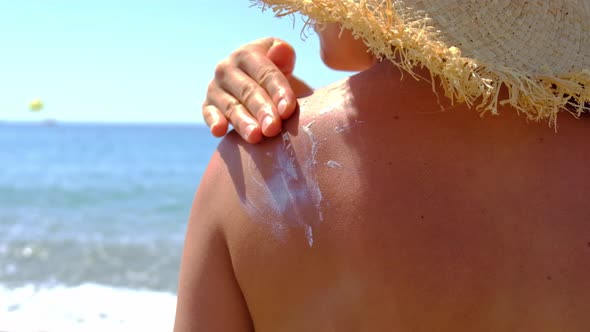 Woman on the Beach Smears Sunscreen