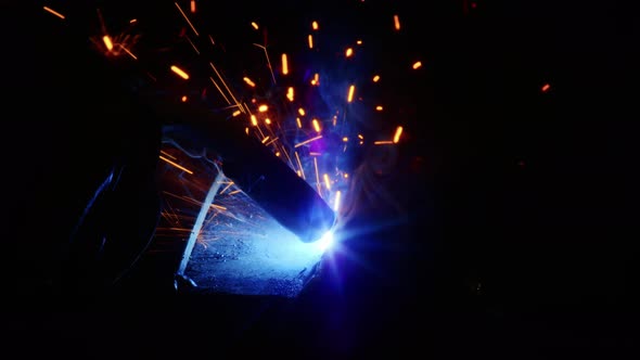 Closeup A Man Welds Plates for Body Armor From Springs