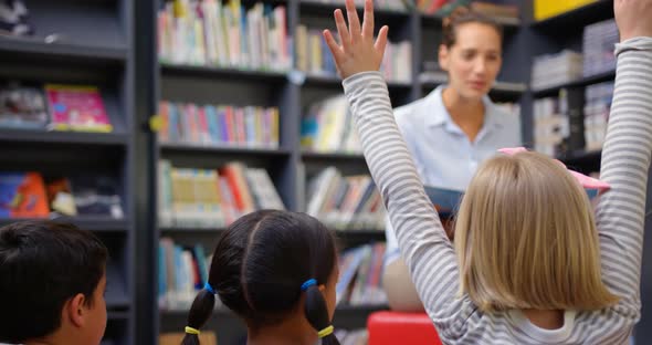 Caucasian female teacher teaching schoolkids in the school library 4k