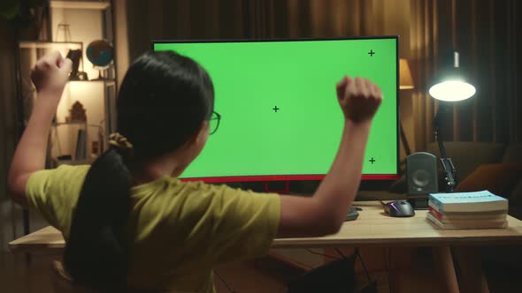 Asian Girl Student Celebrating With Mock Up Computer Green Screen At Home