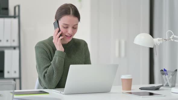 Young Woman Talking on Phone at Work