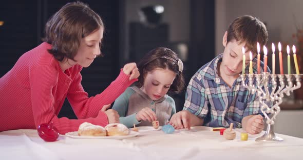 Kids playing with dreidels during Hanukka at home