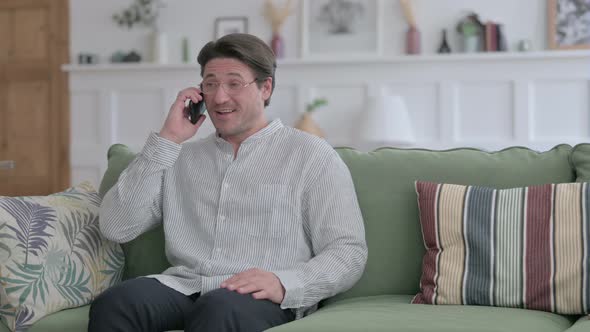 Man Talking on Phone on Sofa