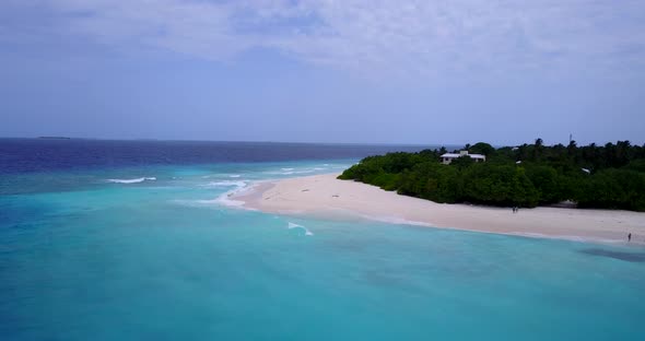 Wide flying tourism shot of a white sand paradise beach and aqua blue water background in colorful 4