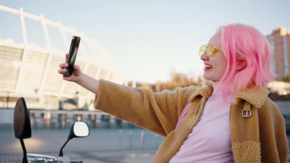 Close Up Portrait of Young Cheerful Stylish Woman with Pink Hair Posing to Smartphone Making Selfie