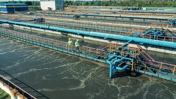 Wastewater Specialists Walking Across the Bridge at a Cleaning Facility