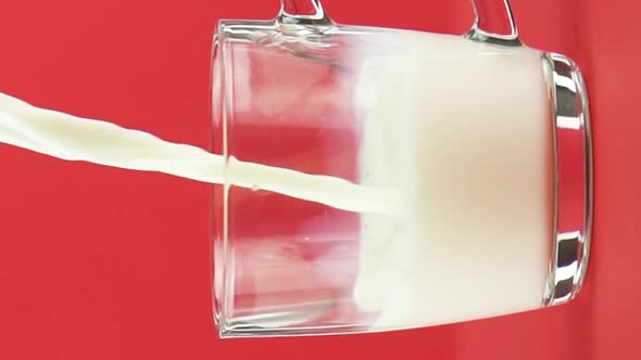 Vertical Video Slow Motion Closeup Shot of Cold Diary Milk Cold Beverage Drink Pooring Into Glass