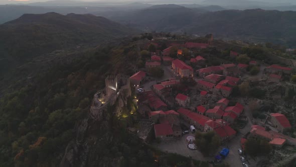 Drone aerial panorama of historic village of Sortelha with castle and with turbines on natural lands