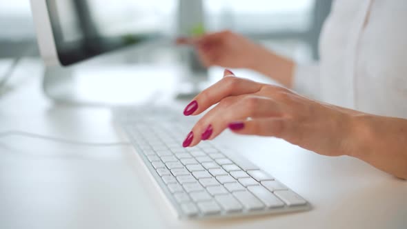 Woman Typing Credit Card Number on Computer Keyboard