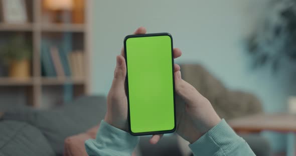 Man Holding Smartphone with Green Mock Up Screen