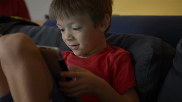 Child Play with Tablet on Sofa at Home with His Dad