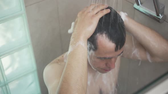 Man Washes His Hair in the Shower