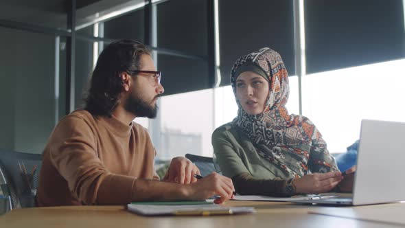 Arab Businessman Talking with Female Colleague in Hijab