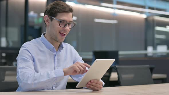 Young Man Having Success on Tablet at Work