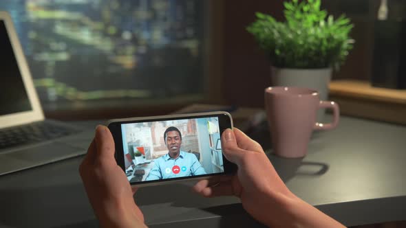 Horizontal Smartphone Screen with Video Calling to the Black Businessman at Office